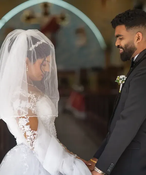 A quiet moment for the couple at the church entrance before the ceremony begins. The veil adds a touch of softness and intimacy to this beautiful Catholic wedding photograph.
