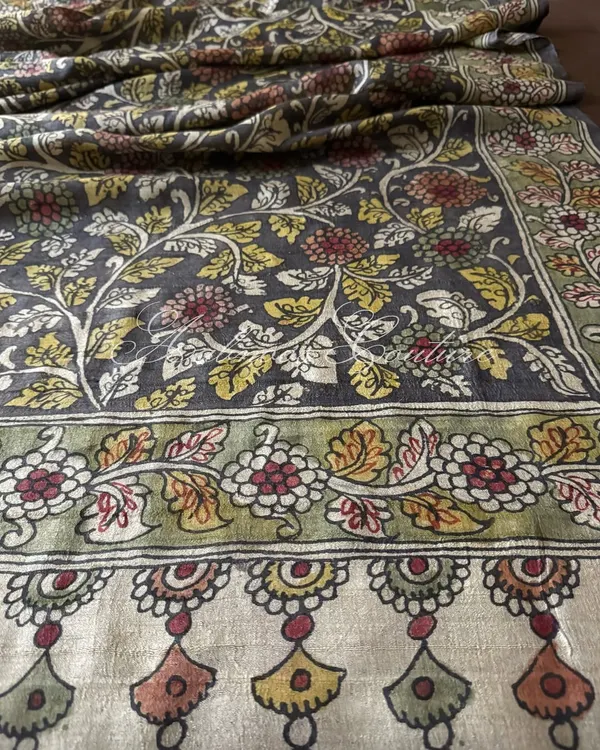 A detailed view of the border of our charcoal grey silk dupatta. It features a traditional floral border in earthy tones, complementing the intricate vine pattern of the main body.