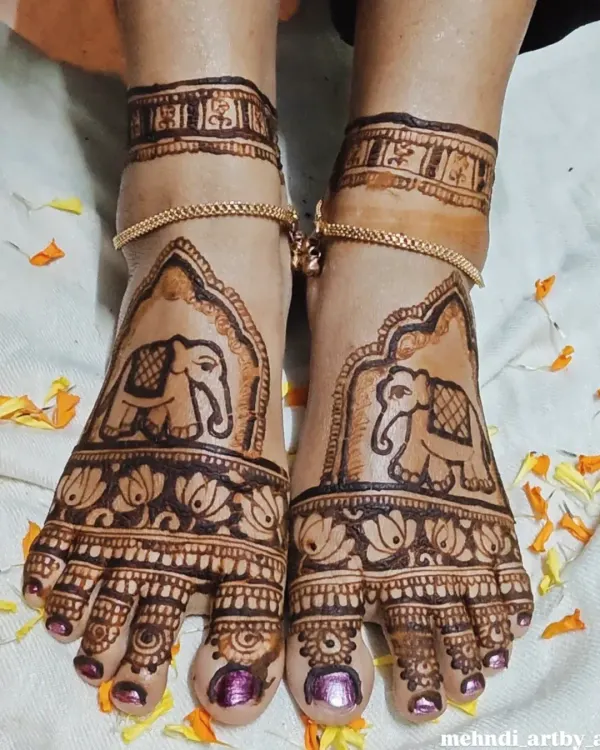 This bridal foot mehendi features majestic elephant motifs, symbolizing strength and good luck. The design covers the top of the feet and includes delicate patterns on the toes.