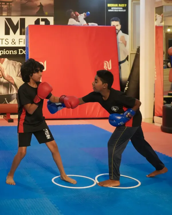 Our youth boxing program teaches more than just how to punch; it builds discipline and strategic thinking. Here, two young fighters practice their sparring techniques, learning footwork and defense under the watchful eye of our coaches.