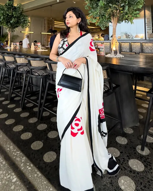 This is the perfect example of a modern saree look for a lunch date or a special day out. I’ve paired a stunning hand-painted saree with a contrasting halter neck blouse and a structured black bag to create a look that’s both chic and unforgettable.