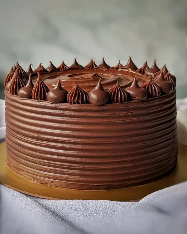 You can never go wrong with a classic chocolate cake. This one is covered in rich, dark chocolate ganache with a simple but elegant piped border.