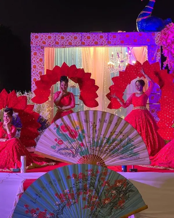 A beautiful Varmala ceremony setup in Mysore, featuring our dancers in red costumes with large fan props. We create a stunning visual backdrop for the couple's most important moments.