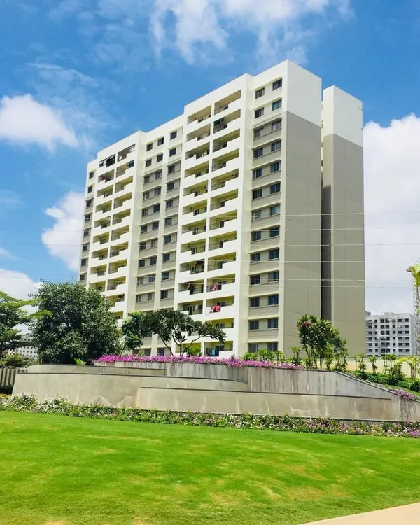 A wide view of a landscaped area for a multi-story apartment building, featuring a lush green lawn and manicured garden beds. This demonstrates our work on large residential projects.