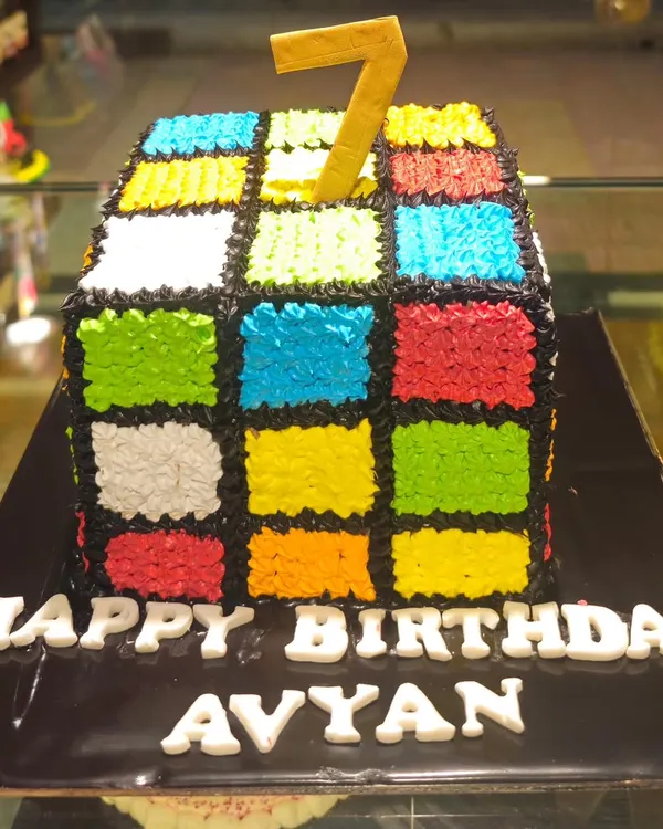 A puzzle you can eat. This Rubik's Cube cake is meticulously decorated with colorful frosting squares to look just like the classic 80s toy, perfect for a themed party.