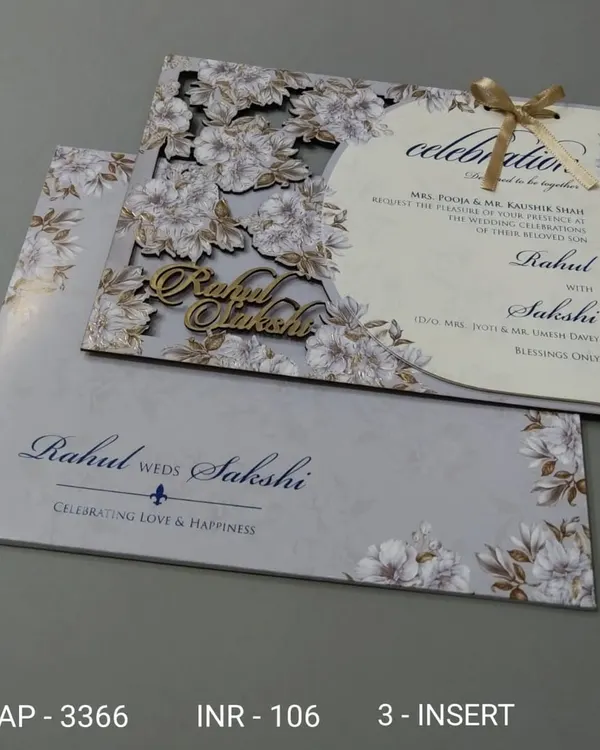 This invitation features a beautiful floral laser-cut cover over a grey background. The couple's names are also laser-cut from wood, adding a personalized and rustic element.