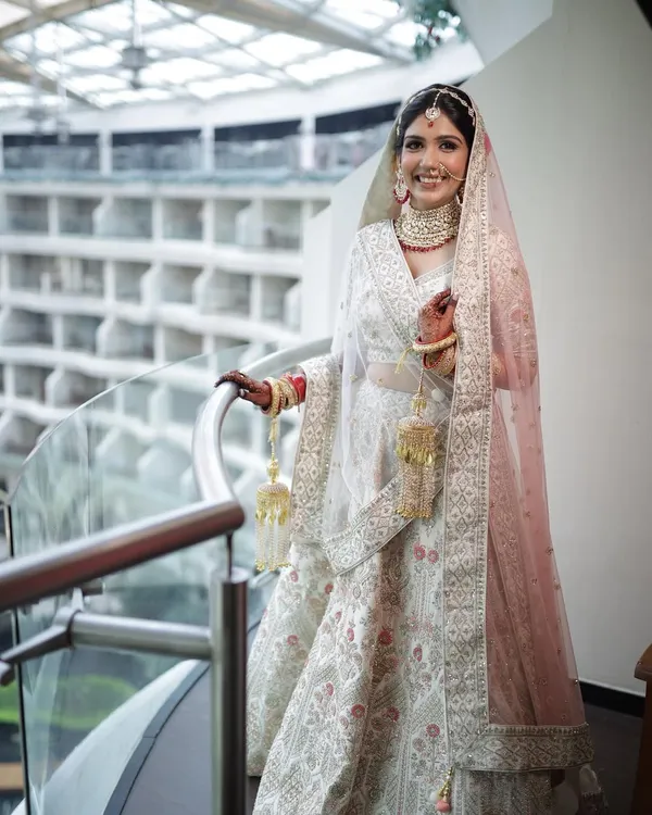 An absolutely angelic bride. Her smile and the stunning ivory lehenga are the stars, supported by a soft, glowing makeup look.