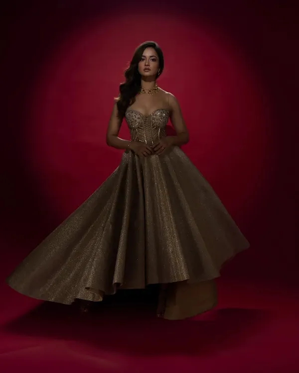 Designed for actress Shanvi Srivastava, this shimmering gold gown features a structured corset and a dramatic, high-low asymmetrical skirt. It's a high-fashion look, perfect for a red carpet event or a glamorous reception.