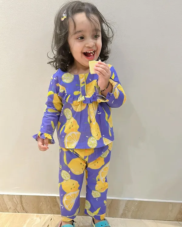 A happy toddler in her comfy lemon-print nightwear. Made from butter-soft cotton, this pajama set is designed for maximum comfort, making bedtime a little more cheerful.