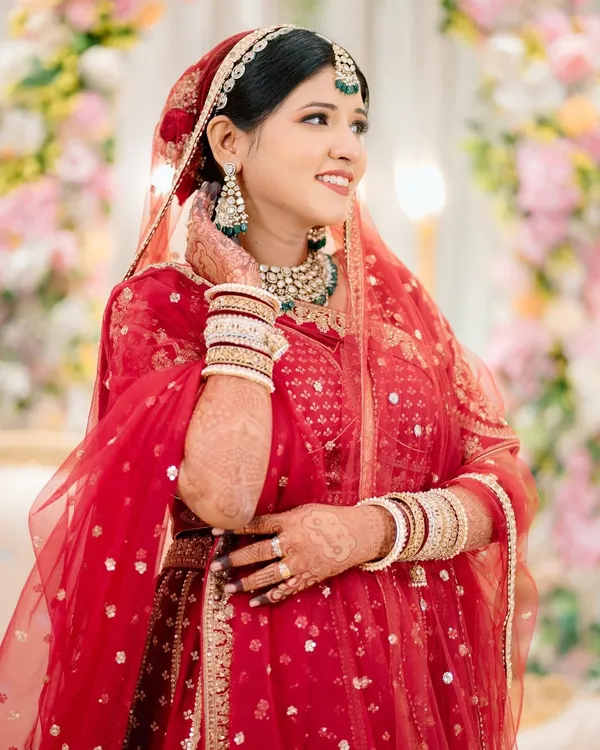 A radiant bridal portrait. The bride's happy, candid expression and the beautiful floral background come together perfectly in this shot.