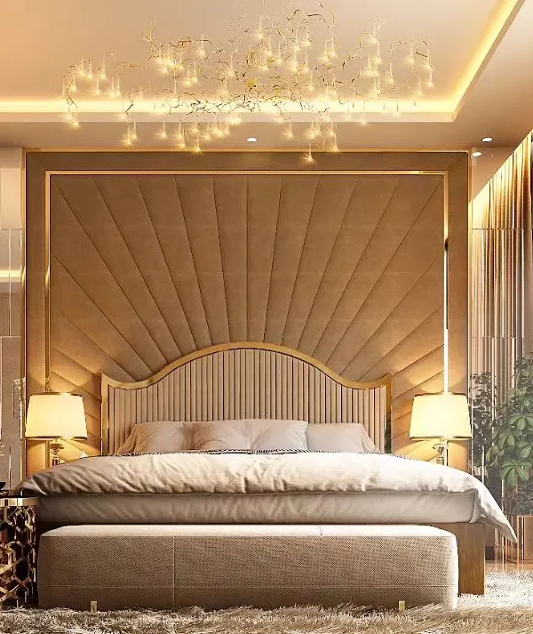 This master bedroom is the epitome of hotel-inspired luxury. A magnificent, full-wall headboard with a sunburst upholstery pattern and gold trim creates a breathtaking focal point, complemented by a cascading crystal chandelier.