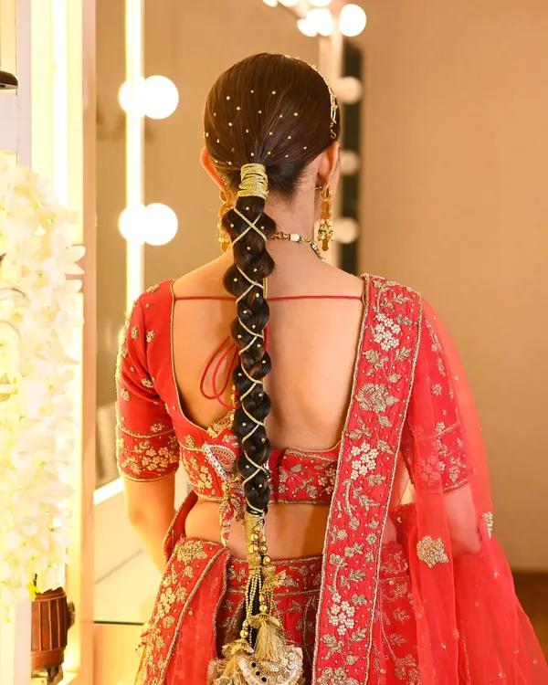 This is a modern take on a traditional bridal braid, also known as a parandi. I created an intricate bubble braid woven with golden thread and accented with tiny pearls for a Sangeet or wedding look.
