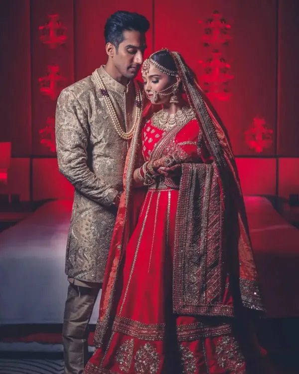 A regal portrait of a couple in a room bathed in red light. This kind of color and mood-setting is a signature of our cinematic style.