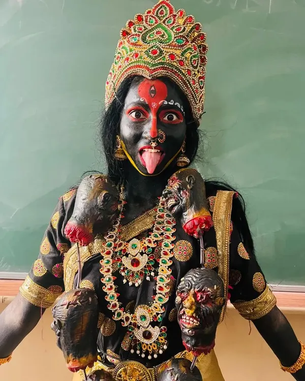 The complete Goddess Kali look, ready for the stage. The combination of intense black body paint, striking red and white details, and traditional costuming creates a truly memorable character.