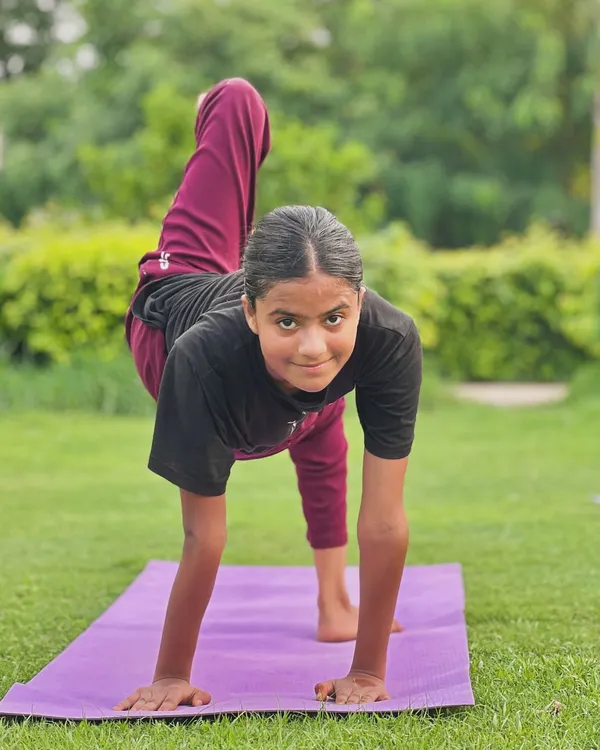 Twist, twist. This young student shows great form and focus in a twisting arm balance, building strength and coordination.