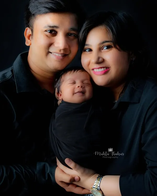 The purest joy on a newborn's face, nestled safely between his loving parents. A classic family portrait that you will cherish forever.