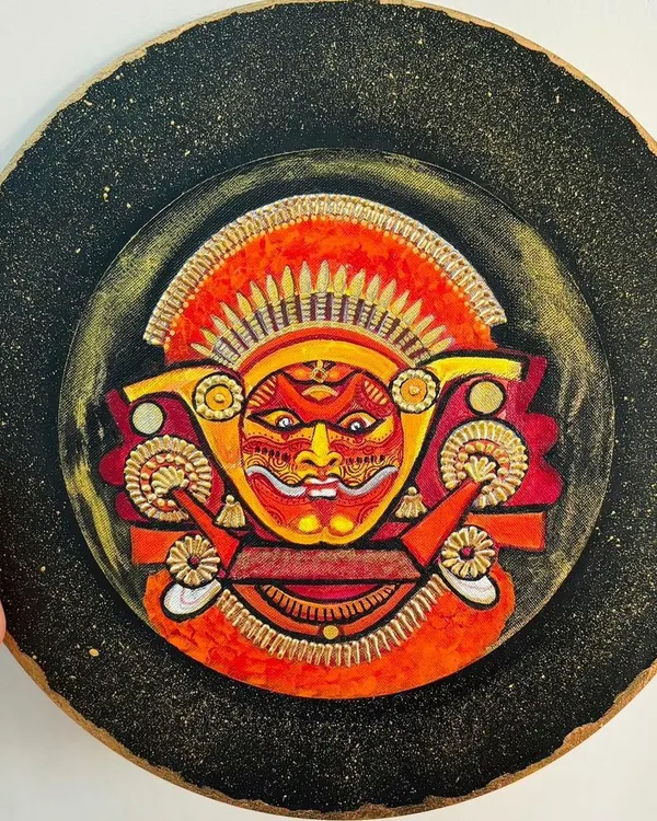 This Theyyam wall plate captures the fierce and divine expression of the ritual dancer. I used a textured black background with gold dust to evoke the mystical atmosphere of a performance by firelight.