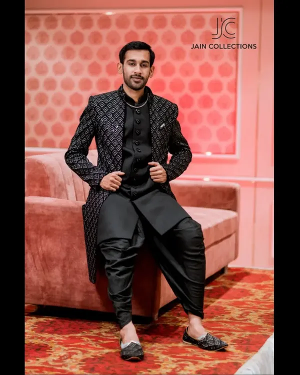 This black on black Indo-Western outfit is the definition of suave. The textured jacket paired with draped dhoti pants is a sharp, modern look for any evening event.