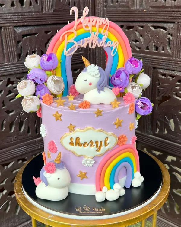 This magical unicorn and rainbow cake is one of my most popular designs for kids. It features two handmade fondant unicorns, colorful rainbows, and pretty flowers on a pastel purple buttercream base.