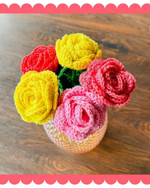 This handmade crochet rose bouquet, featuring a mix of vibrant red, yellow, and pink blossoms, is arranged in a lovely vase. It's a perfect centerpiece that brings lasting color to any room without any need for watering.