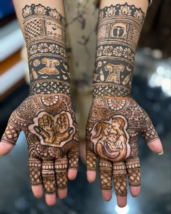 This is one of my favorite baby shower designs, a perfect way to celebrate the mom-to-be. On the left palm, a parent's hands hold tiny baby feet, and on the right, a loving portrait of the new family. The forearm bands include cute details like a baby frock, feeding bottle, and the due date, making it a truly personal seemantha mehendi.