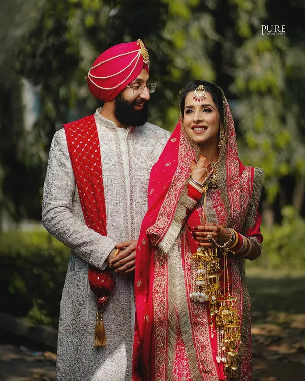 A candid moment between the bride and groom during their outdoor portrait session. The groom's loving gaze captures the essence of their Sikh wedding day.
