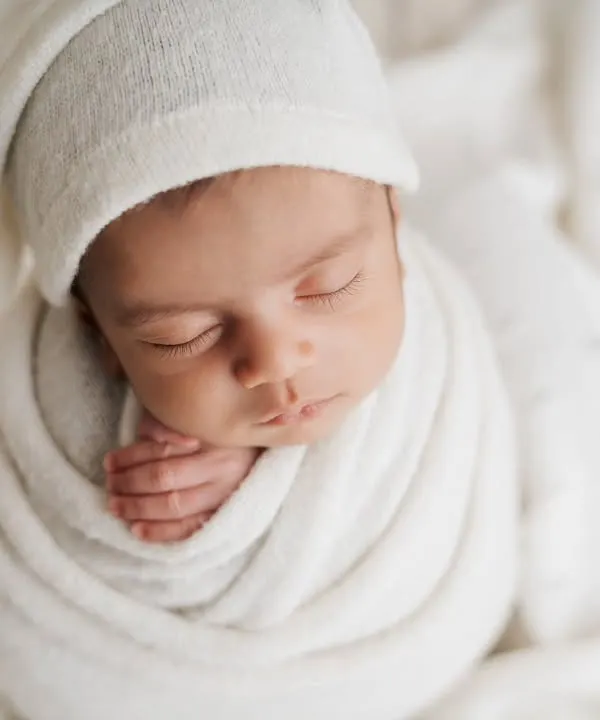 There's nothing more classic than a baby in all white. Swaddled snugly with a little sleepy hat, this portrait is pure, simple, and timeless.