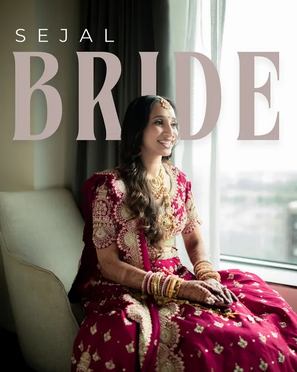 A portrait of the bride, Sejal, seated by the window. The natural light beautifully illuminates her intricate red lehenga and her serene, happy expression.