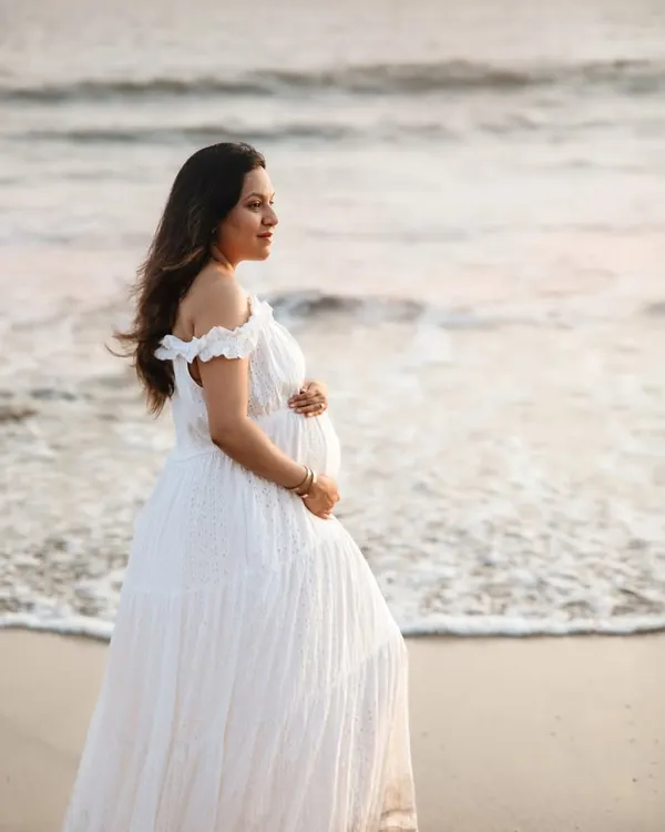 A serene solo portrait on the beach. The soft evening light and the sound of the waves create a perfect backdrop for capturing the peaceful and powerful journey of motherhood.