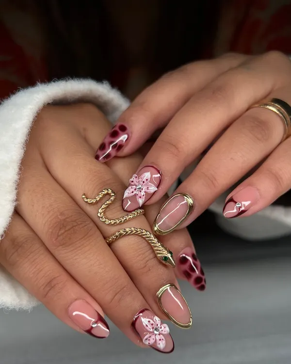 A mixed-media set showcasing my hand-painted skills. This look combines a delicate floral design, a trendy tortoiseshell pattern, and a negative space nail with a gold chrome border.