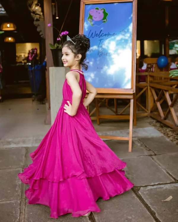 This custom magenta birthday gown was designed to be a showstopper. The layered skirt adds volume and movement, while the simple, elegant bodice and halter neck keep it comfortable for a full day of celebration.