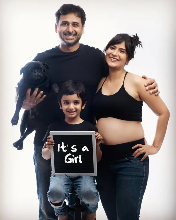 The whole crew is ready! This fun family portrait includes the soon-to-be big brother and the family pug, announcing "It's a Girl!" with a cute chalkboard sign.