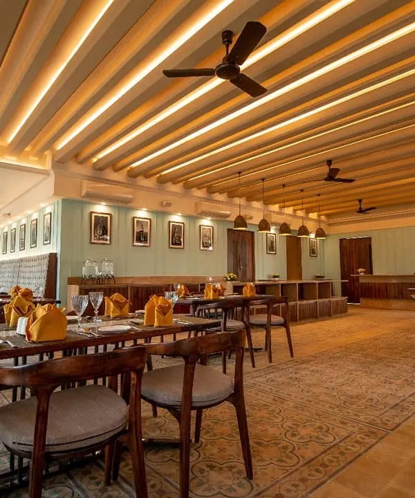 The colonial-themed interior we designed for Ebony Restaurant in Whitefield, featuring a coffered ceiling with cove lighting, elegant seating, and warm wood tones.