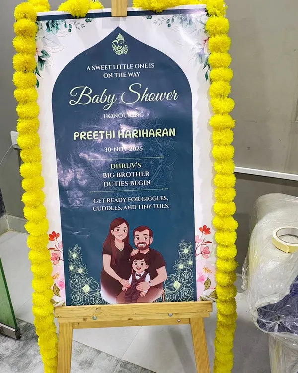 A personalized welcome sign for a baby shower, placed on a wooden easel. I decorate the sign with traditional marigold flowers to match the event's theme.