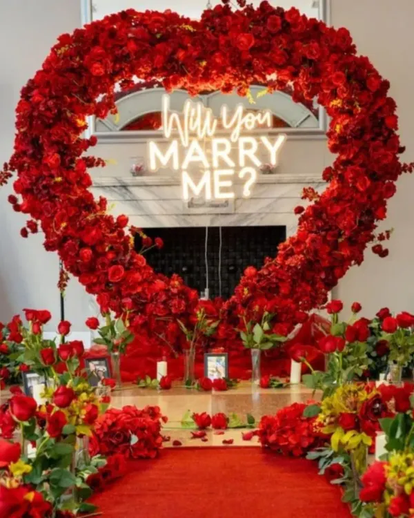 This is the ultimate fairytale proposal setup. I used a heart-shaped arch made entirely of red roses, a custom "Will You Marry Me?" neon sign, and a petal-strewn path to create a truly unforgettable moment.