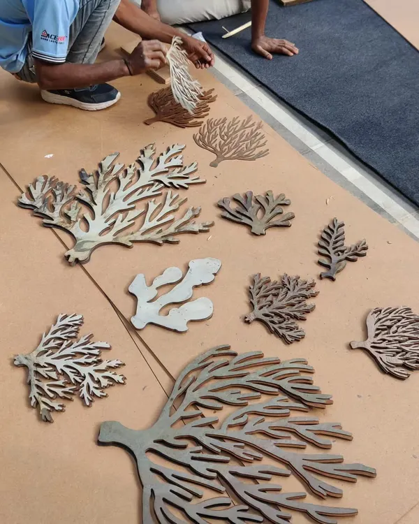 The process of creating our coral awareness installation. Here, our team is laying out the laser-cut coral shapes before assembling them onto the main panel. Every piece was carefully designed to represent different types of coral, creating a rich and detailed texture.
