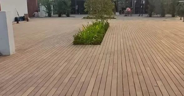 We specialize in large-scale decking projects. This expansive wooden deck creates a clean, uniform surface, with cutouts for trees and plants to integrate nature into the design.