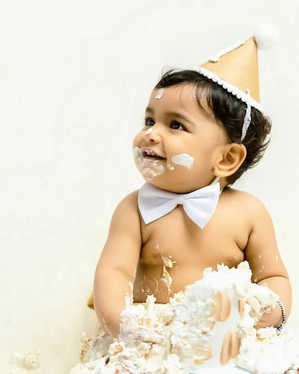 The pure joy of turning one. This little boy, wearing a smart bowtie, is all smiles as he digs into his first birthday cake. This is the classic, happy mess I love to capture.