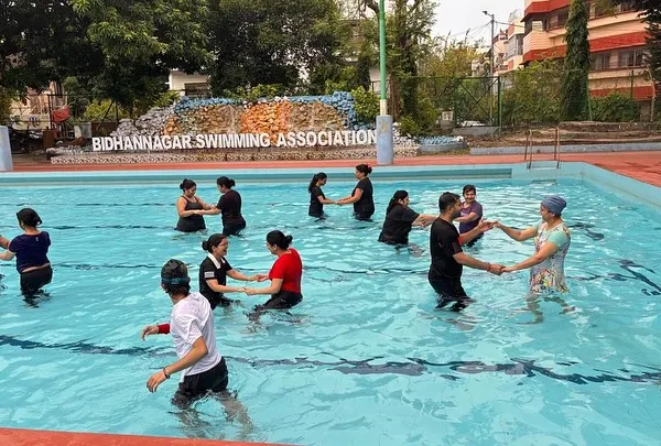 A group of adults enjoying a partnered dance move during our aqua fitness class. The water provides support, making it great for all fitness levels.
