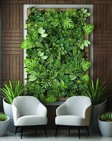 This framed vertical garden serves as a living piece of art. The dense arrangement of artificial monsteras and succulents creates a rich, three-dimensional texture that becomes the focal point of the room, perfectly complementing the modern seating area.