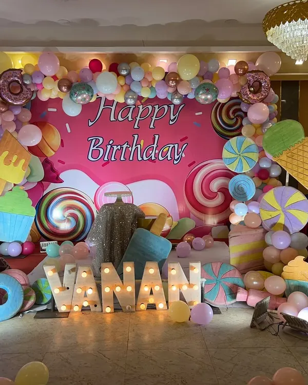 We bring any birthday theme to life, like this vibrant Candyland party. The setup features a custom backdrop with giant lollipops and ice creams, a colorful balloon arch, and large marquee letters spelling out the name for a fun, immersive celebration.