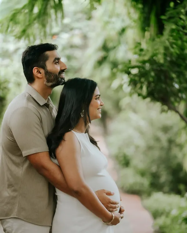 An outdoor maternity portrait for a couple, framed by lush greenery. This session focuses on capturing the shared anticipation and quiet love before the baby arrives.