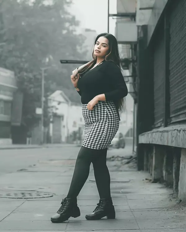 A full-length street style shot from my winter series. The houndstooth skirt and combat boots create a chic, edgy look against the gritty urban background, perfect for a model's portfolio showing commercial and editorial range.
