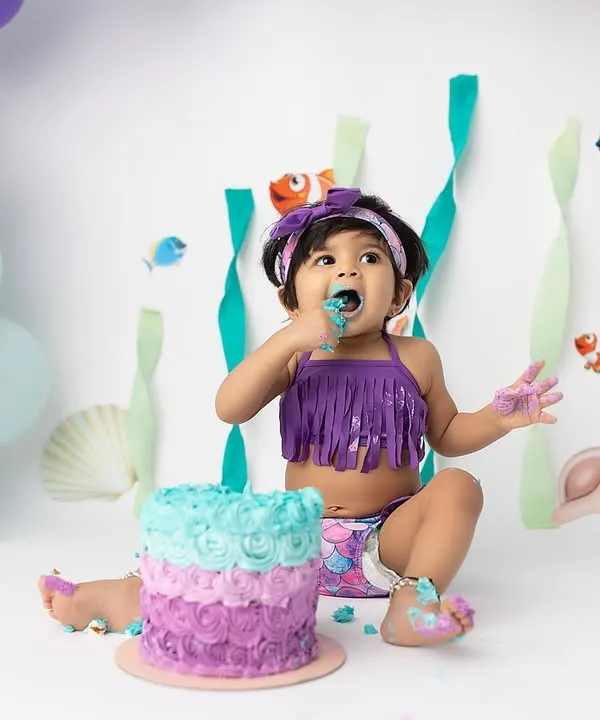 Making a splash with a mermaid-themed cake smash! This little one is having the best time exploring her colorful cake in our "Under the Sea" setup.