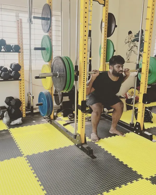 A member executes a deep squat inside the power rack, a core exercise in our program for building overall strength and leg power.