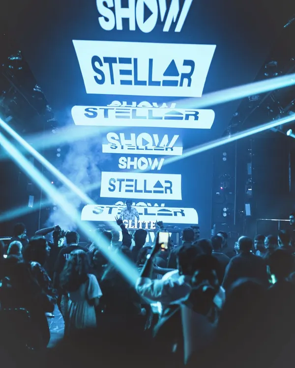 A view from the dance floor at Glitte, with my logo stacked high on the screen and light beams cutting through the haze. This is what an immersive visual experience looks like.