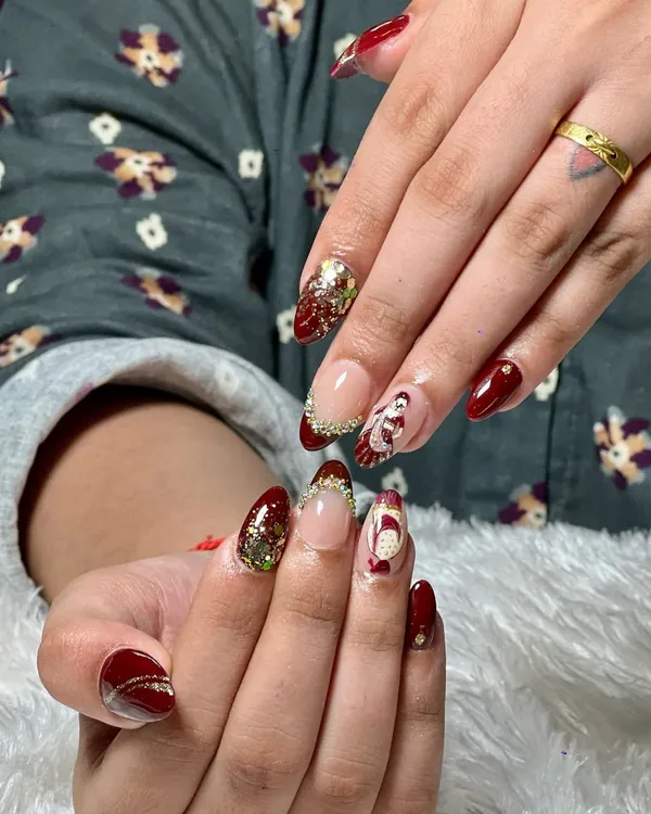 For our brides, we create truly one-of-a-kind nail art. This custom set for a wedding features a deep maroon base, sparkling glitter accents, and a hand-painted traditional bride design, making it a memorable part of the special day.