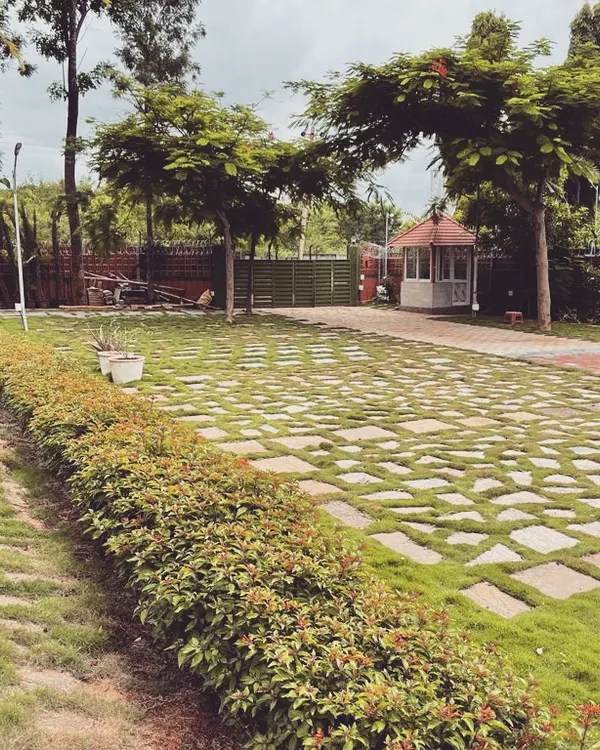 For this large farmhouse property, we designed a sprawling driveway using stone pavers set in a checkerboard pattern with grass. This approach creates a durable surface for vehicles while maintaining a green, permeable landscape.