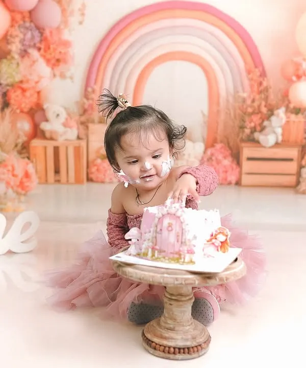 A little one curiously digs into her first birthday cake. This pastel rainbow themed shoot is one of my most popular, creating a soft and dreamy atmosphere.