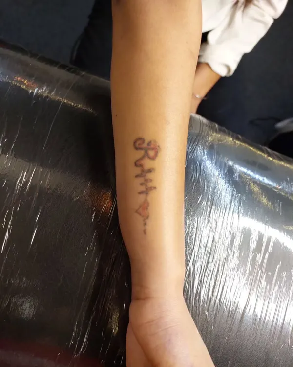 Before: An old, faded name and heart tattoo on the inner forearm that the client wished to cover.